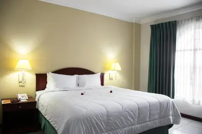 a hotel room with a large bed and a window at Hotel Mirador Plaza in San Salvador