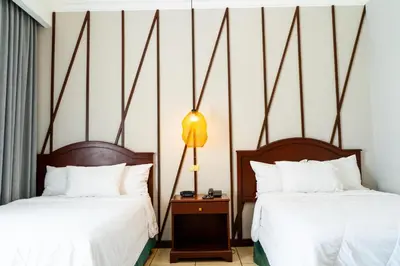 two beds in a hotel room with white sheets at Hotel Mirador Plaza in San Salvador
