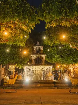 a fountain in a park at night at La Casa de Mamapán Hotel Colonial Ahuachapan in Ahuachapán