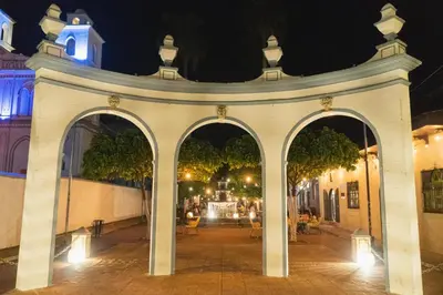 an archway in a city at night at La Casa de Mamapán Hotel Colonial Ahuachapan in Ahuachapán
