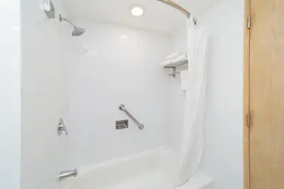 a bathroom with a shower with a shower curtain at Quality Hotel Real Aeropuerto San Salvador in San Luis