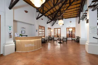 a large room with a lobby with tables and chairs at Quality Hotel Real Aeropuerto San Salvador in San Luis