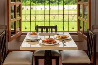 a table with two plates of food on it in front of a window at Quality Hotel Real Aeropuerto San Salvador in San Luis