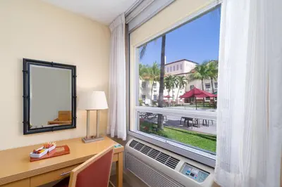 a room with a desk and a large window at Quality Hotel Real Aeropuerto San Salvador in San Luis