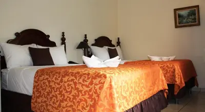 two beds sitting next to each other in a room at Hotel Villa Florencia Zona Rosa in San Salvador