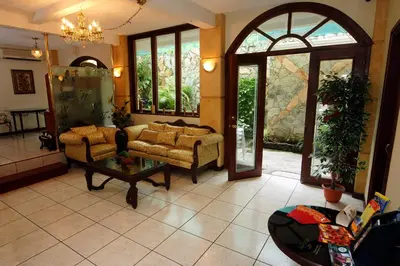a living room with a couch and a table at Hotel Villa Florencia Zona Rosa in San Salvador