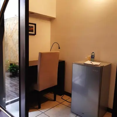 a room with a desk and a chair and a table at Hotel Villa Florencia Zona Rosa in San Salvador
