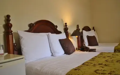 a hotel room with two beds with white pillows at Hotel Villa Florencia Zona Rosa in San Salvador