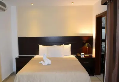 a hotel room with a bed with a white swan on it at Hotel Villa Florencia Zona Rosa in San Salvador