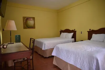 a hotel room with two beds and a table at Hotel Villa Terra in San Salvador