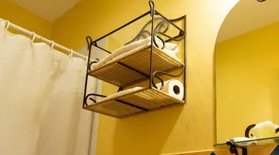 a bathroom with a rack with towels and a mirror at Hotel Villa Terra in San Salvador