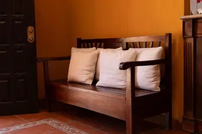 a wooden bench with three pillows on it at Hotel Villa Terra in San Salvador