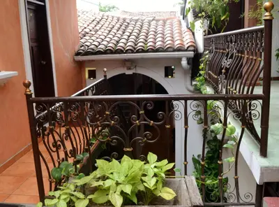 a small balcony with a gate and plants at Hotel Villa Florencia Centro Histórico in San Salvador