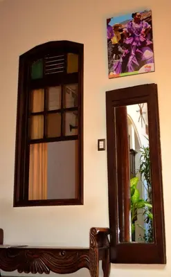 a mirror on a wall with a bench next to it at Hotel Villa Florencia Centro Histórico in San Salvador