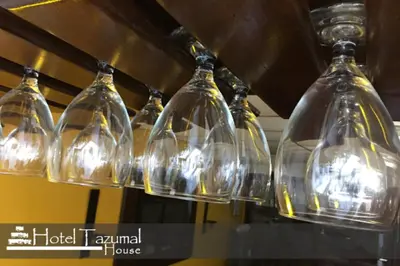 a bunch of wine glasses hanging from a ceiling at Hotel Tazumal House in San Salvador