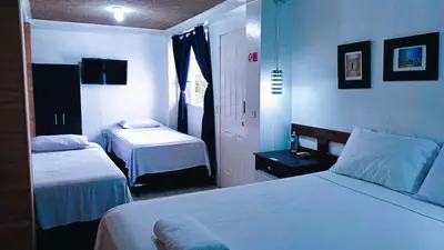 a hotel room with two beds and a window at Hotel Tazumal House in San Salvador