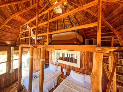 a room with two beds in a wooden cabin at Hotel Tortuga Village in La Herradura