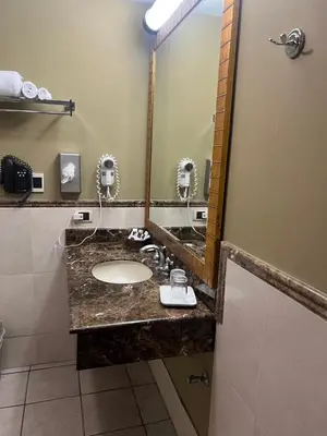 a bathroom with a sink and a mirror at Suites las Palmas, Hotel & Apartments. in San Salvador