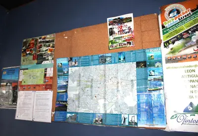 a bulletin board with a map and posters on it at Ximenas Guest House in San Salvador