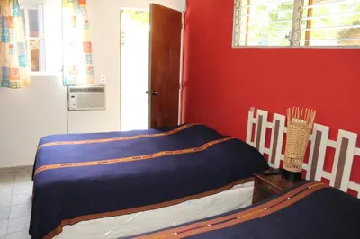 a room with a bed in a red wall at Ximenas Guest House in San Salvador