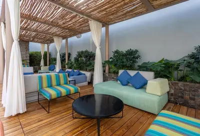 a patio with couches and a table and chairs at Hyatt Centric San Salvador in San Salvador