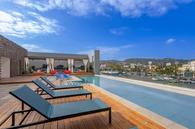 a swimming pool with two lounge chairs on top of a house at Hyatt Centric San Salvador in San Salvador