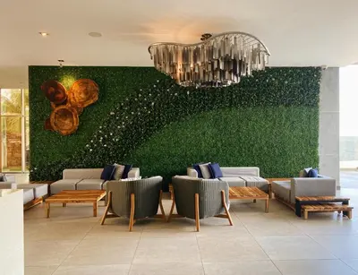 a lobby with a green wall with chairs and a chandelier at Acantilados in La Libertad