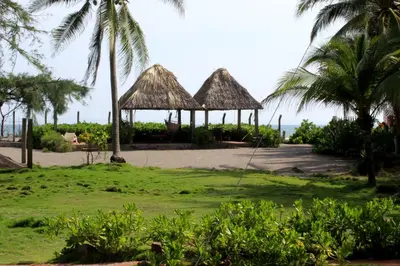 a resort with palm trees and a swing at Capricho Beach House in El Zapote
