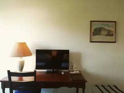 a desk with a television and a lamp in a room at Hotel Berlin in San Salvador