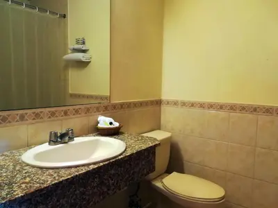 a bathroom with a sink and a toilet and a mirror at Hotel Berlin in San Salvador