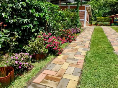 a garden with pink flowers and a brick walkway at Villa Castillo de Ensueño in Concepción de Ataco