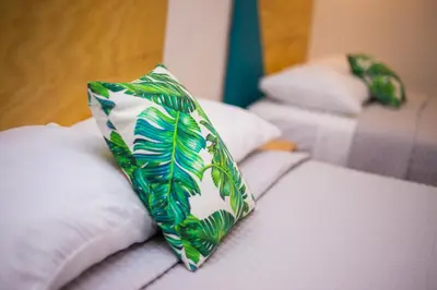 a green and white tie sitting on top of a bed at Hotel Citlalli in San Salvador