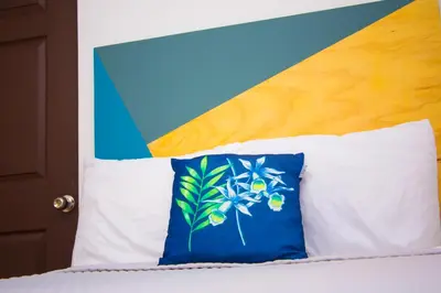a bed with a blue and white pillow on it at Hotel Citlalli in San Salvador