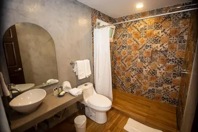 a bathroom with a toilet and a sink and a mirror at Hotel Citlalli in San Salvador