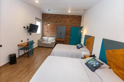 a hotel room with two beds and a couch at Hotel Citlalli in San Salvador
