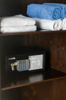 a remote control on a shelf with towels at Palo Verde Sustainable Hotel in El Zonte