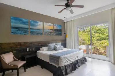a bedroom with a bed and a large window at Palo Verde Sustainable Hotel in El Zonte