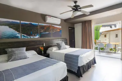 a hotel room with two beds and a balcony at Palo Verde Sustainable Hotel in El Zonte