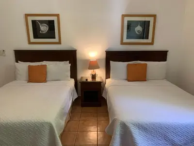 two beds in a hotel room with at Hotel La Posada del Angel in San Salvador