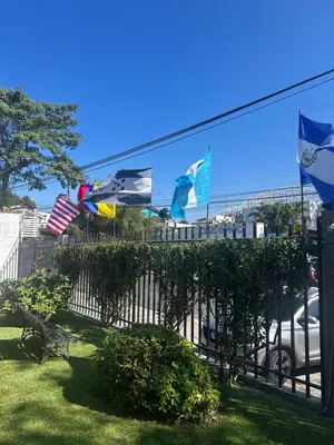 a fence with flags in front of a building at Hotel La Posada del Angel in San Salvador