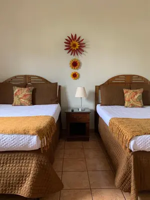 a bedroom with two beds and a table with a lamp at Hotel La Posada del Angel in San Salvador