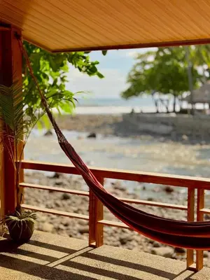 a hammock hanging from a fence on a beach at Esencia Nativa in El Zonte