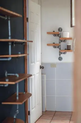 a room with wooden shelves next to a door at Esencia Nativa in El Zonte
