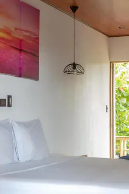 a bedroom with a bed and a pendant light at Esencia Nativa in El Zonte