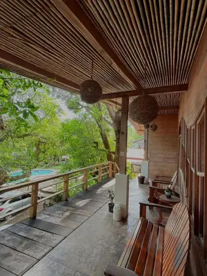 a wooden porch with a bench on a deck at Esencia Nativa in El Zonte