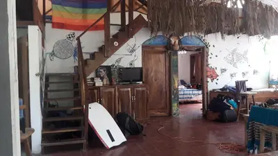 a living room with a surfboard on the wall at Casa de Colores in El Zonte