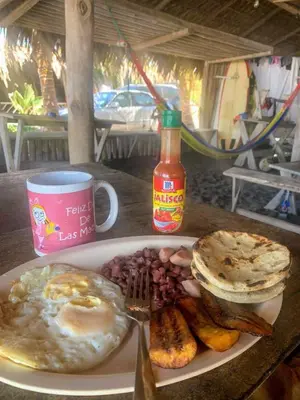 a plate of breakfast food with eggs beans and toast at Pelicano Surf Camp in La Libertad