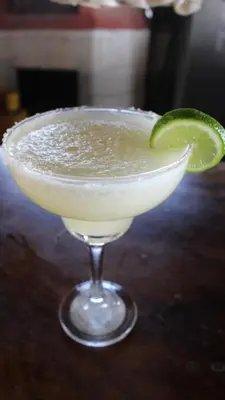 a margarita in a glass with a lime wedge at Pelicano Surf Camp in La Libertad