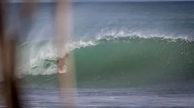 a person riding a wave on a surfboard in the ocean at Pelicano Surf Camp in La Libertad