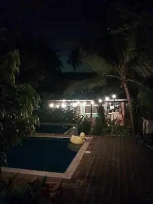a swimming pool at night with a resort at Hammock plantation in El Zonte